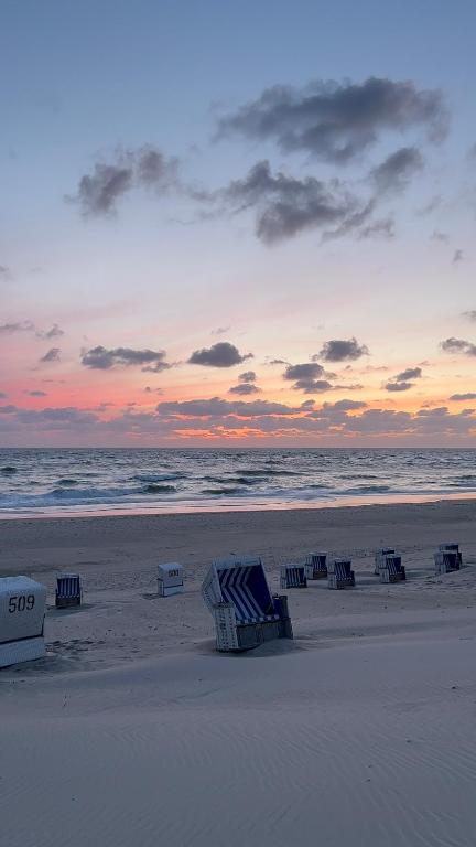 un gruppo di sedie a sdraio in spiaggia al tramonto di Privates Domizil auf Sylt in Strandnähe a Westerland