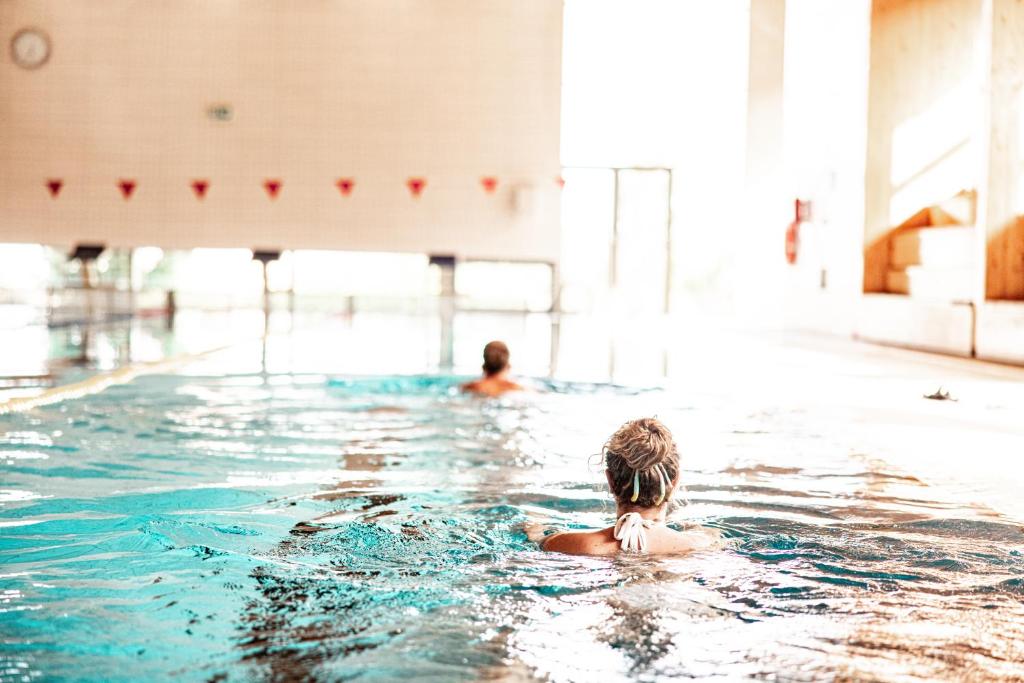 duas pessoas a nadar numa piscina em Akadémia Hotel em Balatonfüred