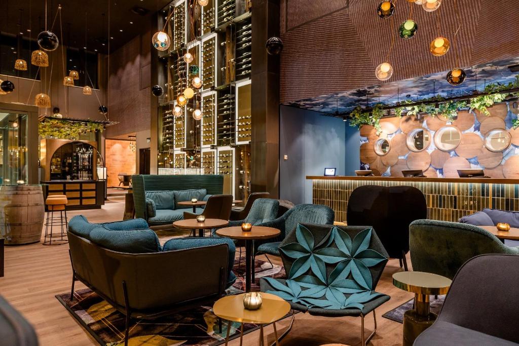 un restaurant avec des tables et des chaises bleues ainsi qu'un bar dans l'établissement Motel One Wiesbaden, à Wiesbaden