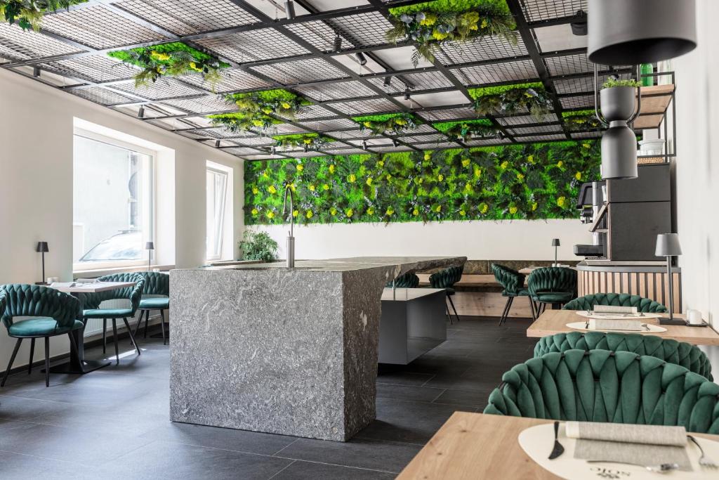 um restaurante com plantas verdes no tecto em Sole Boutique Hotel em Vipiteno