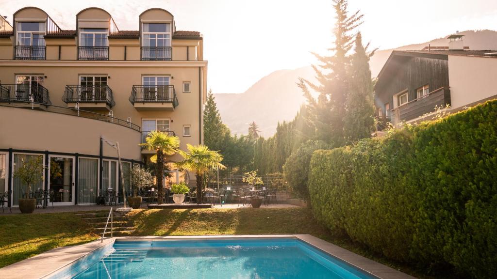 una piscina in un cortile accanto a un edificio di Hotel Villa Laurus a Merano