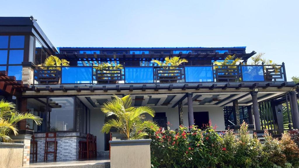 une maison avec des balcons bleus au-dessus dans l'établissement Difrika Country Resort, à Jinja