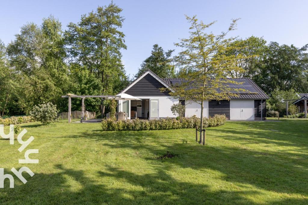 een klein huis in een tuin met een boom bij OV072 Exklusives 4P-Ferienhaus in bester Lage in Giethoorn in Giethoorn