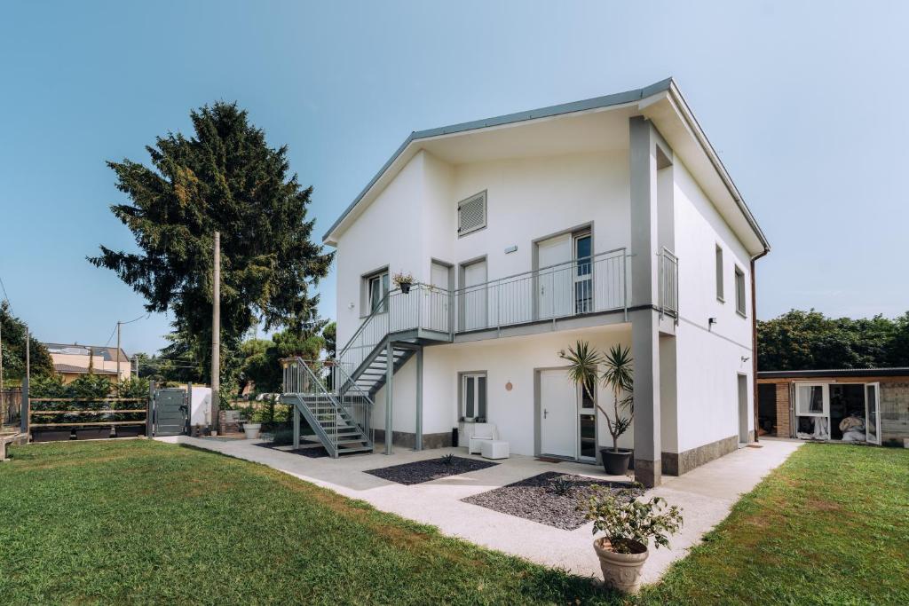 a white house with a staircase and a yard at Sleep & Fly Villa Luisa in Case Nuove