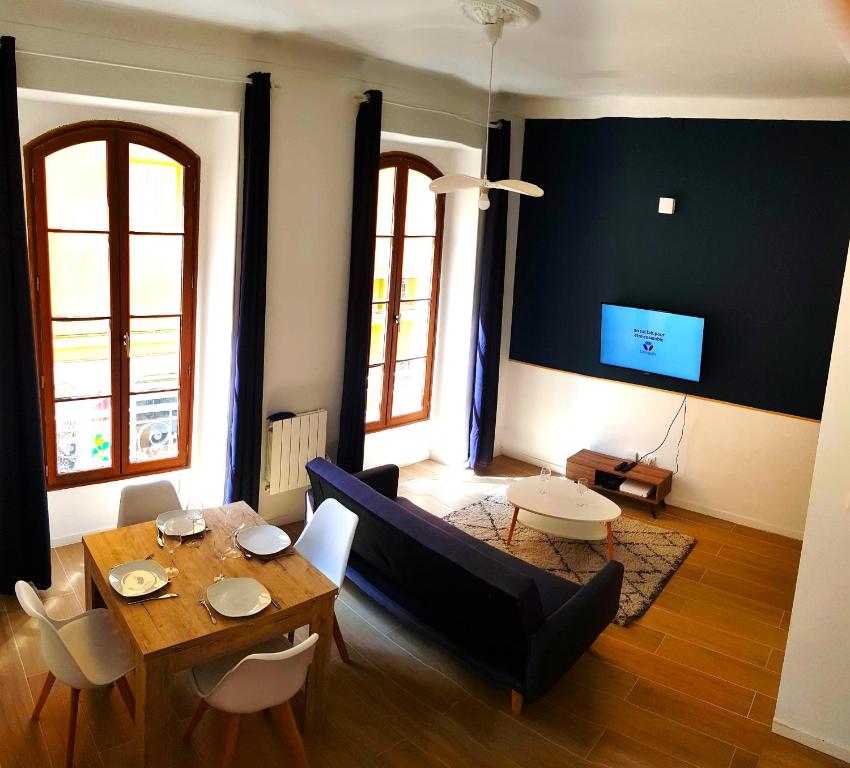 a living room with a table and a couch at BIG FLAT - LE CALA - Hypercentre - 4 chambres, 13 personnes, proche plage gare et parking, WIFI, Air Conditioning l GROUPE l BUSINESS l FAMILLE in Nice