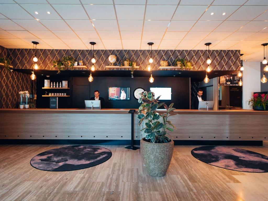 un ristorante con bancone e bar di Mercure Paris Orly Rungis Aéroport a Rungis