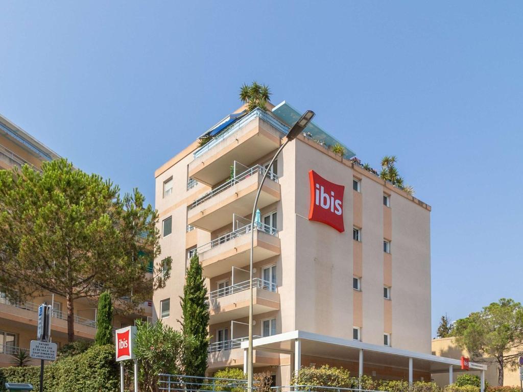 um grande edifício branco com uma placa de lops sobre ele em Ibis Roquebrune Cap Martin Menton em Menton