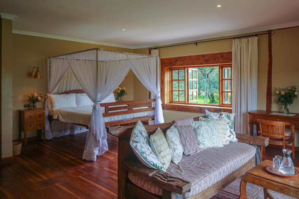 een woonkamer met een bank en een bed bij Mukima Manor in Nanyuki