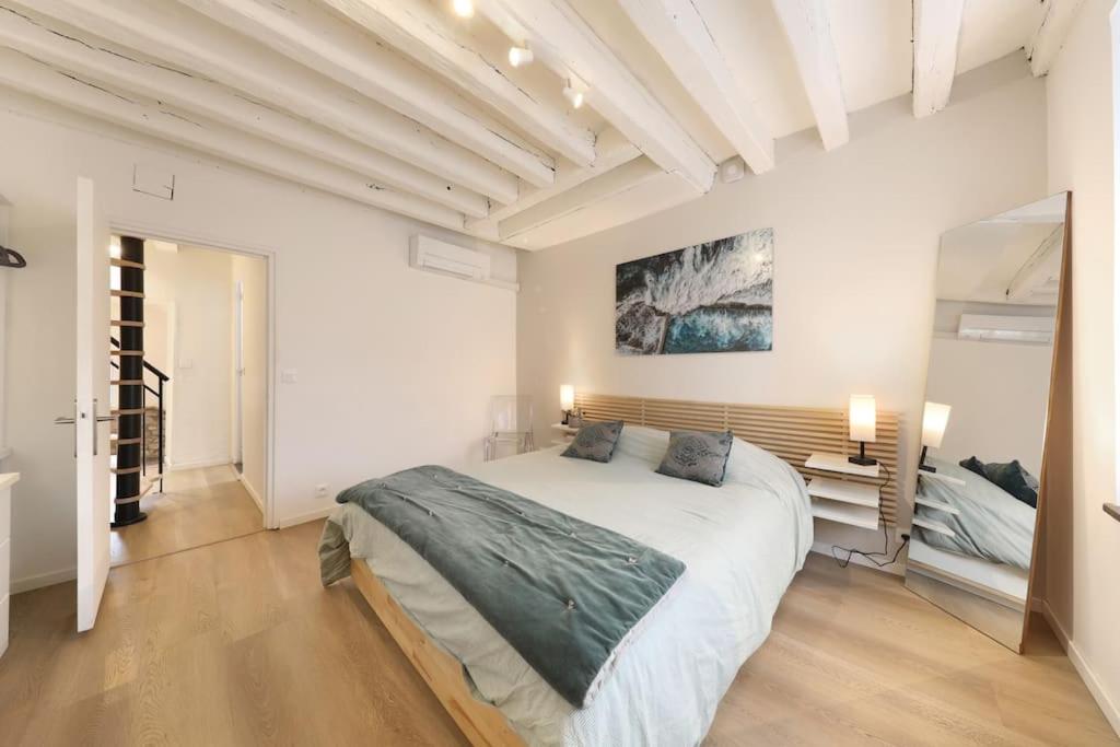 una camera da letto con un grande letto in una stanza bianca di Maison exception proche CDG Paris Astérix Chantilly Climatisation parking a Orry-la-Ville