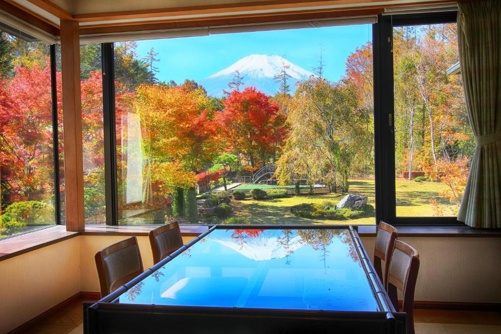 a table with a view of a mountain through a window at Hatago Tsubakiya in Yamanakako