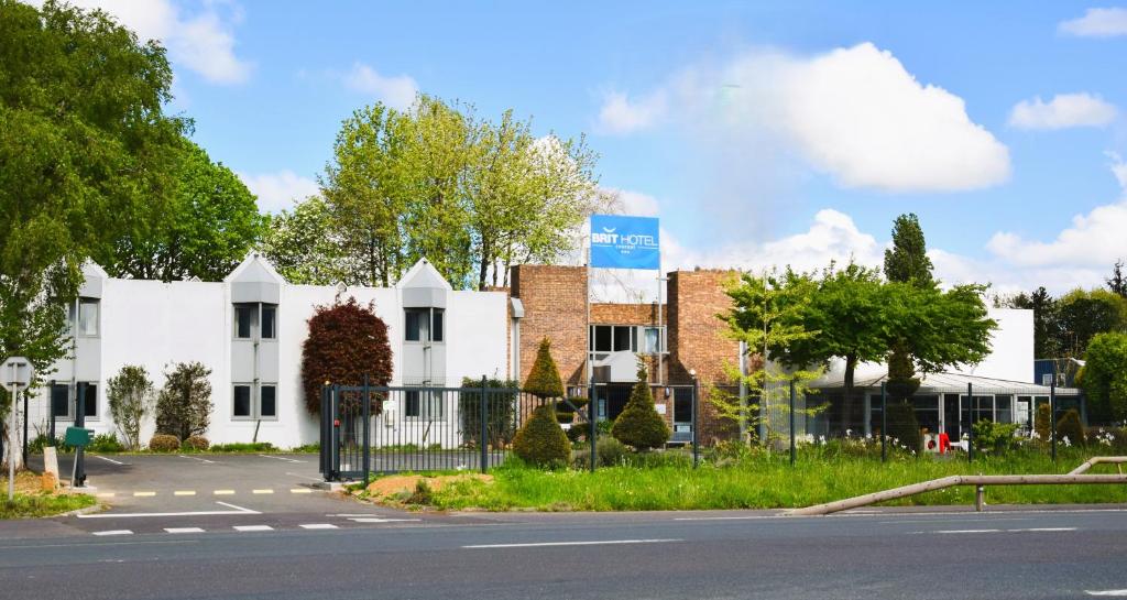 een wit gebouw aan de straatkant bij BRIT HOTEL Caen Hérouville in Hérouville-Saint-Clair