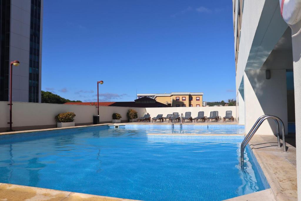 uma grande piscina ao lado de um edifício em VIP Executive Zurique Hotel em Lisboa