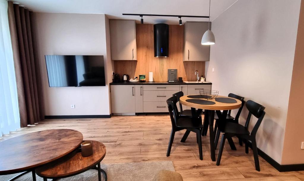 uma cozinha e sala de jantar com mesa e cadeiras em Apartamenty przy Tężni em Busko-Zdrój