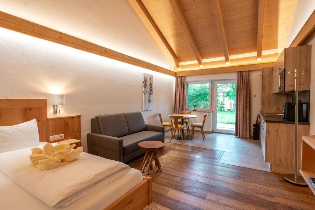 a bedroom with a bed and a chair and a table at Wellness-Appartements Berchtesgadener Land in Ainring