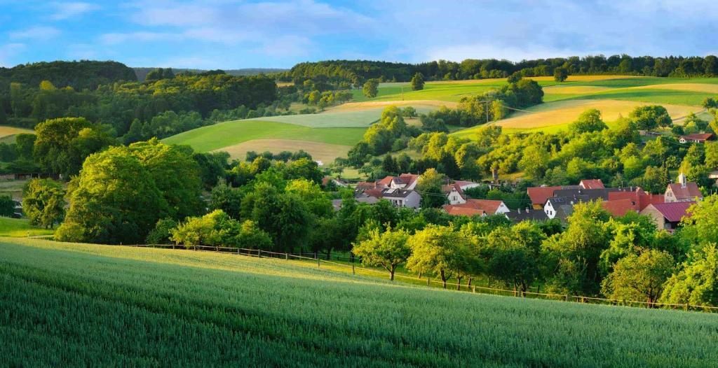 ein Dorf in den Hügeln mit grünem Feld in der Unterkunft Gartenhaus - Dietzhäuschen in Suhl