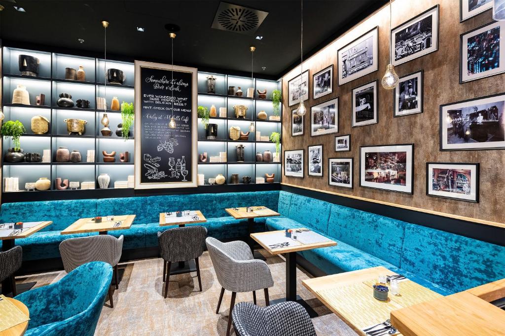 un restaurant avec des tables, des chaises et un tableau noir dans l'établissement Three Corners Avenue Hotel, à Budapest