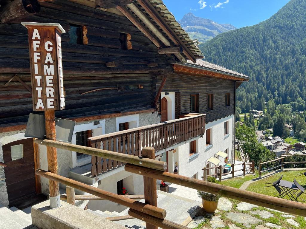 un edificio con un balcón con un cartel. en Affittacamere Buenavista Guest House, en Champoluc