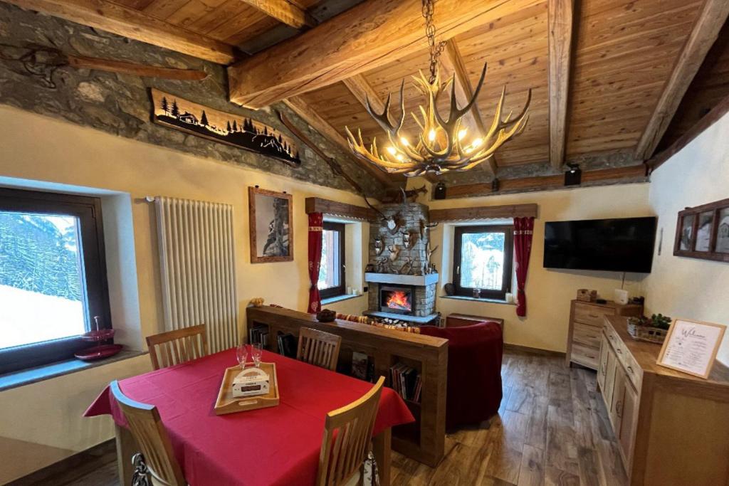 a dining room with a table and a chandelier at Chalet Chez Louis - Alpine Charm with Mont Blanc View & Ski Access in Courmayeur