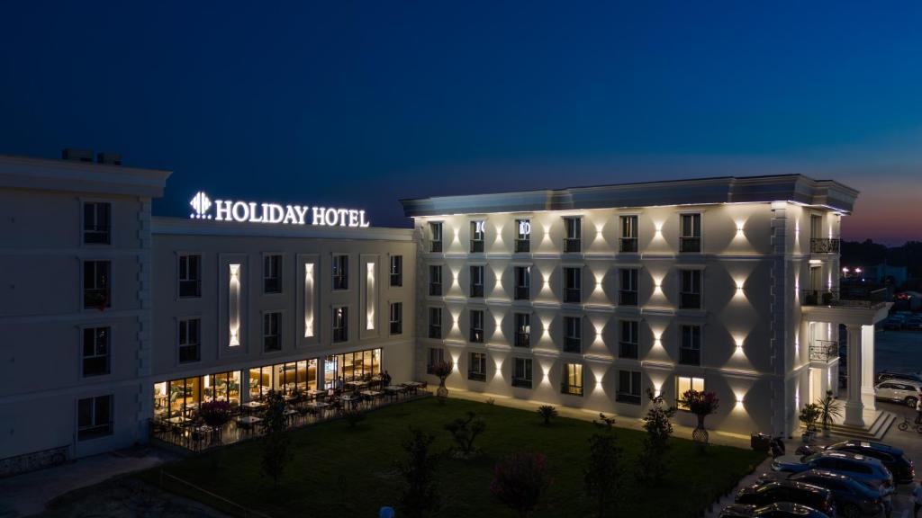 hotel z oświetlonym budynkiem w nocy w obiekcie Holiday Hotel w Tiranie