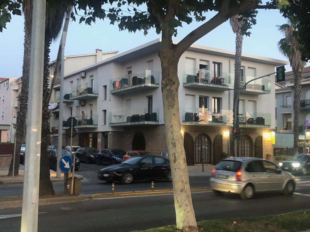 una strada con auto parcheggiate di fronte a un edificio di Eliton ad Alghero