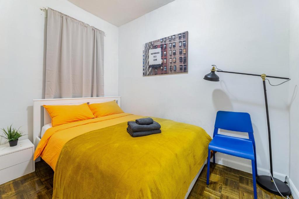 - une chambre avec un lit jaune et une chaise bleue dans l'établissement Hidden Cozy 2BD apartment In Manhattan, à New York