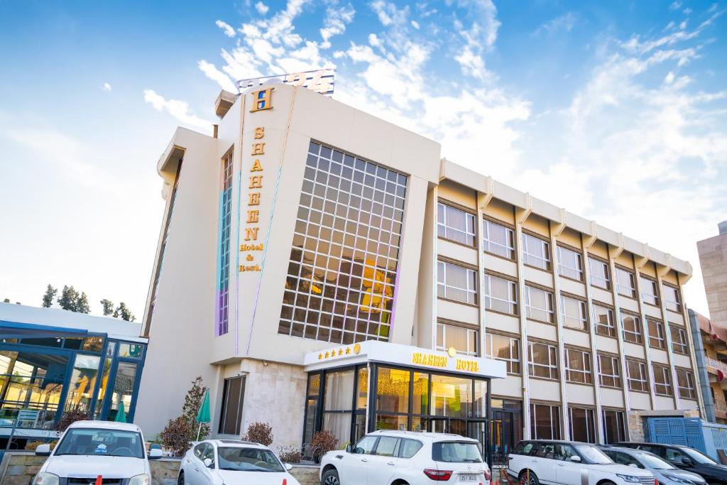 un edificio con coches estacionados frente a él en Shaheen Hotel Baghdad, en Baghdād