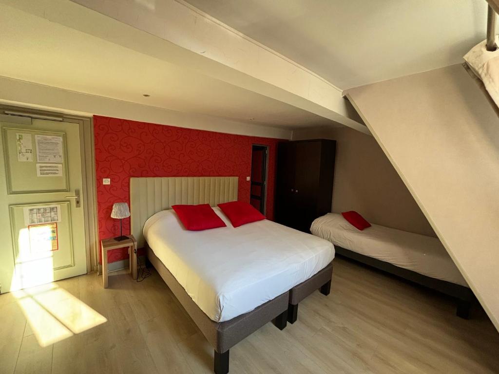 a bedroom with two beds and a red wall at Hotel Le Jacquemart in Dijon