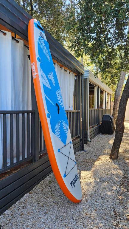 una tabla de surf naranja y azul colgando de una casa en BIOGRAD MOBILE HOME OASIS, en Biograd na Moru