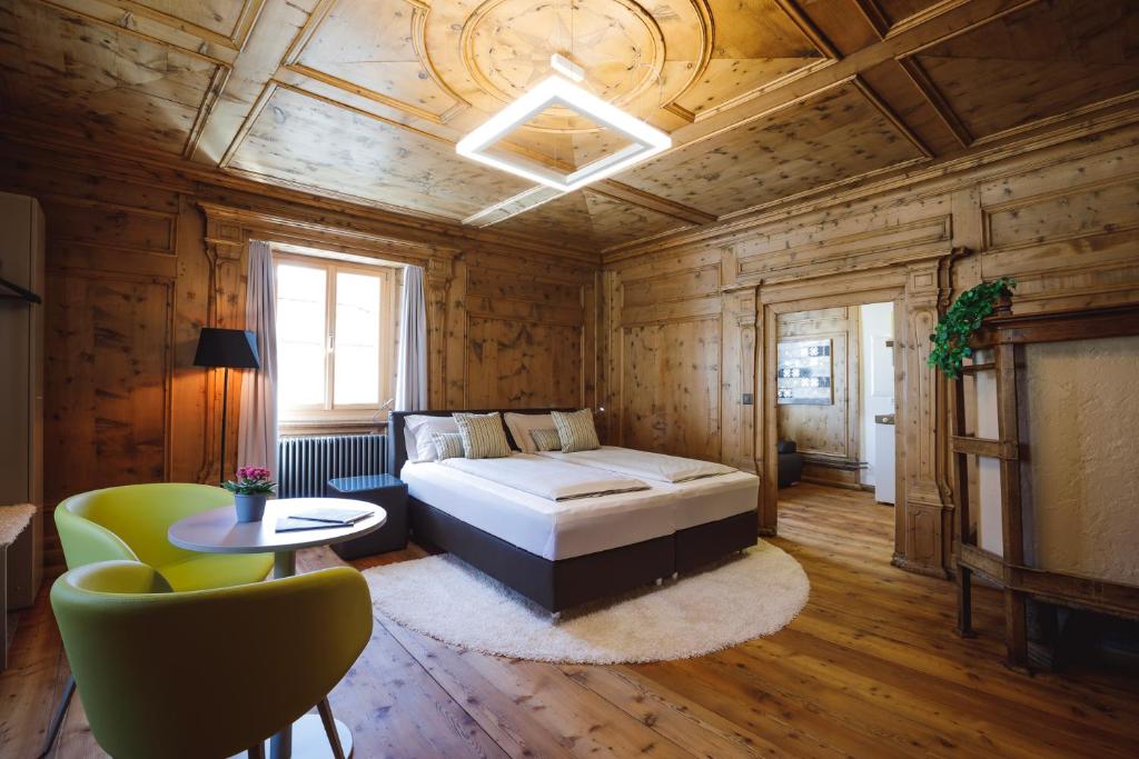 1 dormitorio con cama, sofá y mesa en Ca' del Borgo, Rooms & Suites, en Poschiavo