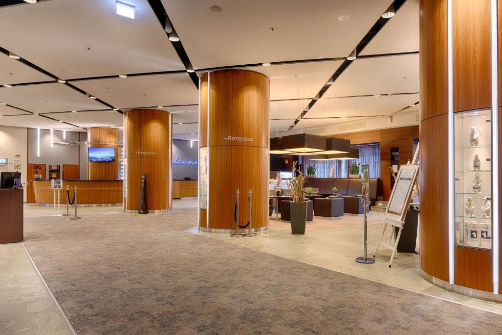 eine große Lobby mit Säulen und Ausstellungsstücken in einem Gebäude in der Unterkunft Park Inn by Radisson Berlin Alexanderplatz in Berlin