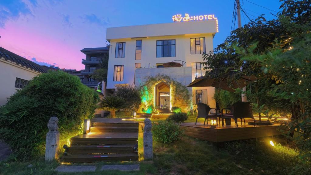 a building with a lit up sign in front of it at Dao Bian Inn in Zhangjiajie