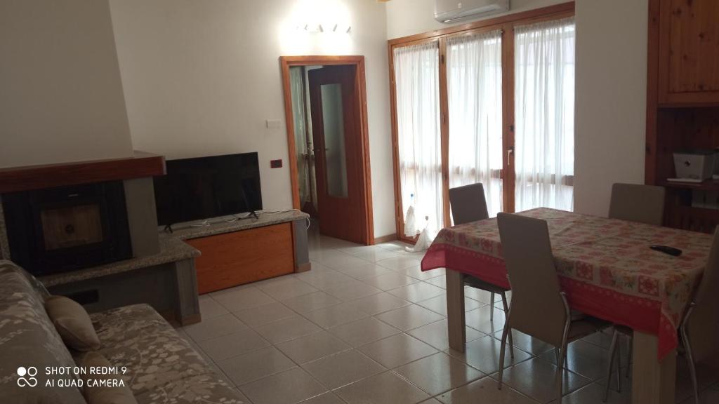 uma sala de estar com uma mesa e uma televisão em Casa Vanda em Luino