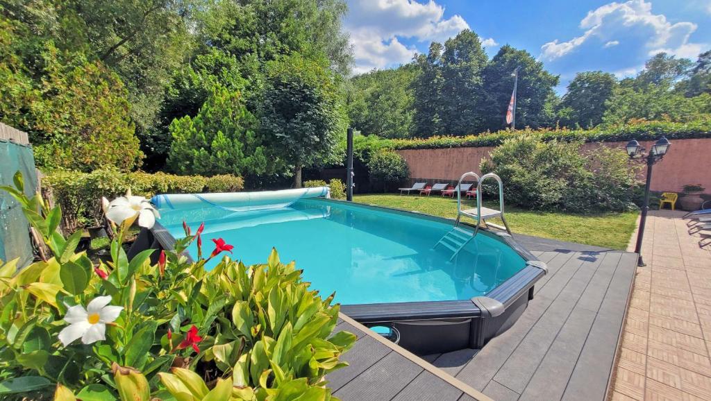 a swimming pool in a yard with flowers at Locanda Le Panche in Pistoia