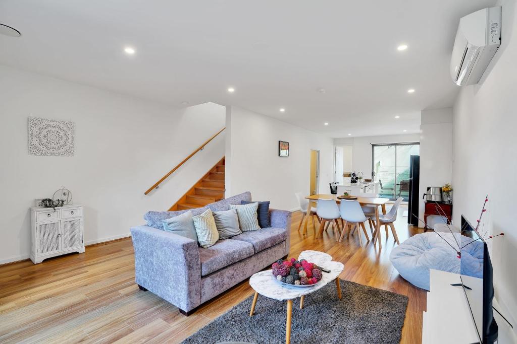 a living room with a couch and a table at Cozy Townhouse in Werribee centre in Werribee