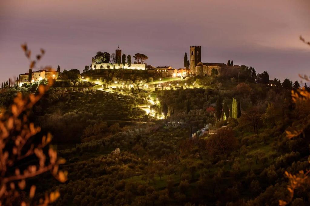 ein Schloss, das nachts auf einem Hügel liegt in der Unterkunft La Monastica Resort & Spa in Borgo a Buggiano