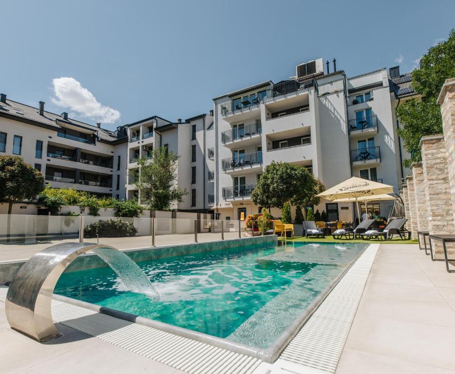 una piscina con una fuente en un edificio en Hotel Auris, en Szeged