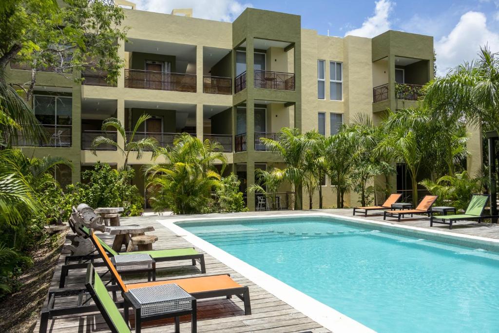 uma piscina de resort com cadeiras e um edifício em LOL-HA Hotel Boutique em Cancún