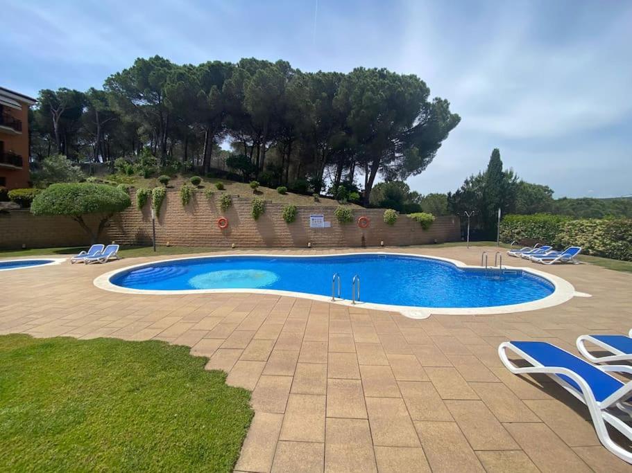 una piscina con due sedie a sdraio e un gruppo di Apartamento Loft, LLoret de Mar a Lloret de Mar