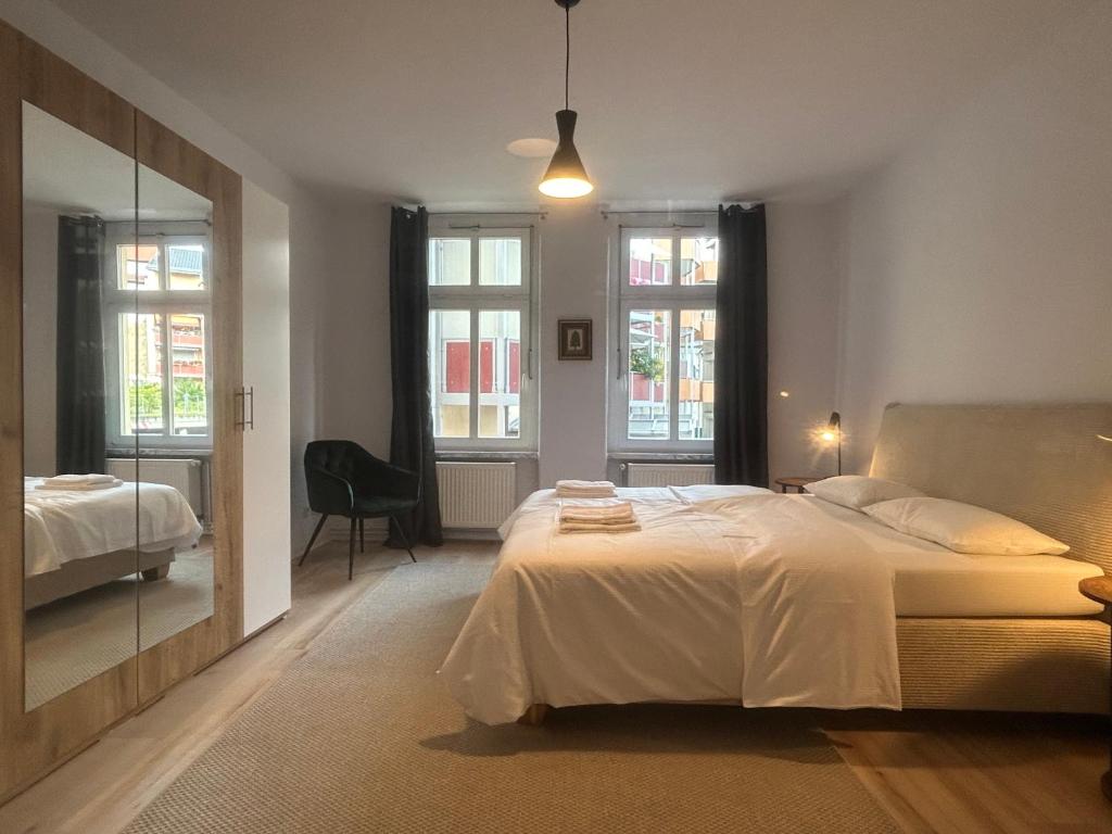 - une chambre avec un grand lit et un miroir dans l'établissement Maximi Loft - Ferien & Business, à Merseburg