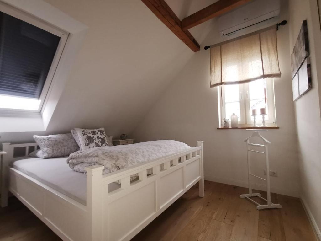 a bedroom with a white bed and a window at Schwarzwaldpanorama Doppelzimmer-WC in Ettlingen