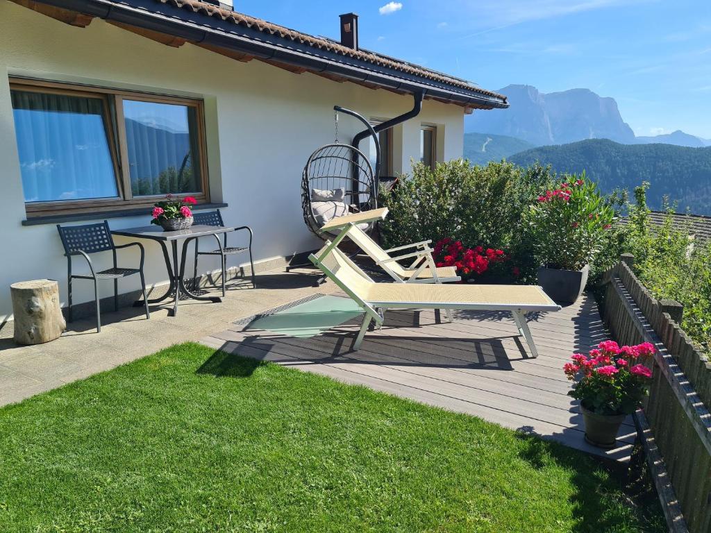 eine Holzterrasse mit einer Bank und einem Tisch in der Unterkunft Apartment Sassun in Lajen