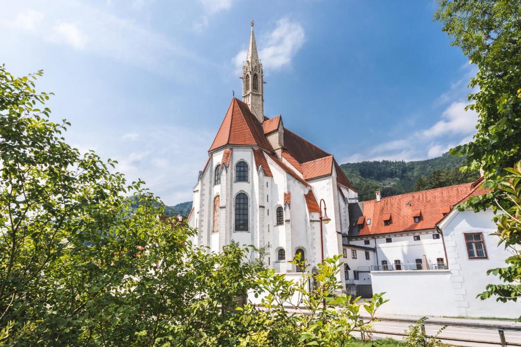 una vecchia chiesa bianca con un campanile su una collina di Hotel Kartause a Gaming