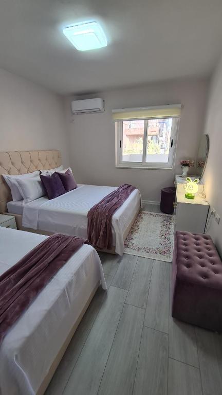 a bedroom with two beds and a window at Dei Cozy Apartment in Shkodër