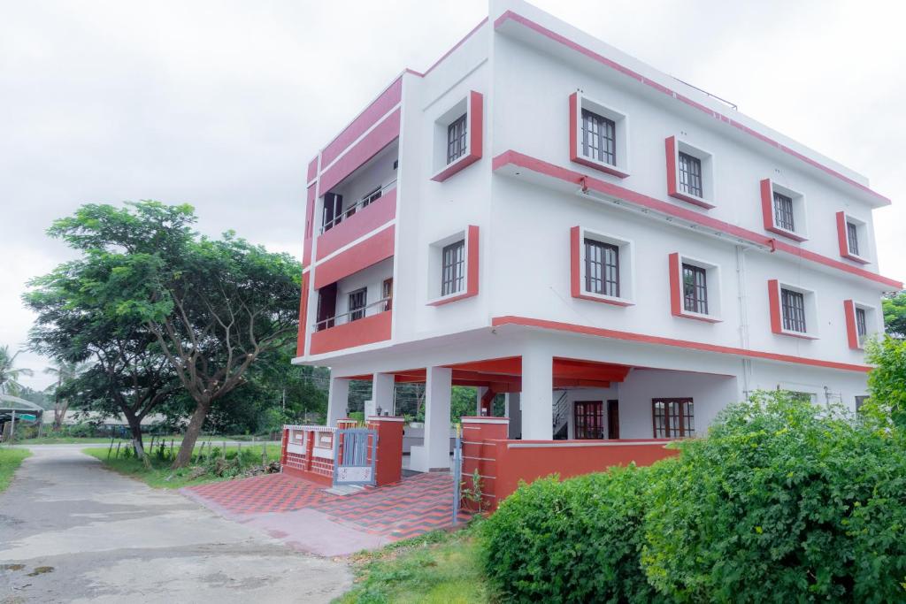 um grande edifício branco com acentos vermelhos em Coorg Residency home stay em Kushālnagar