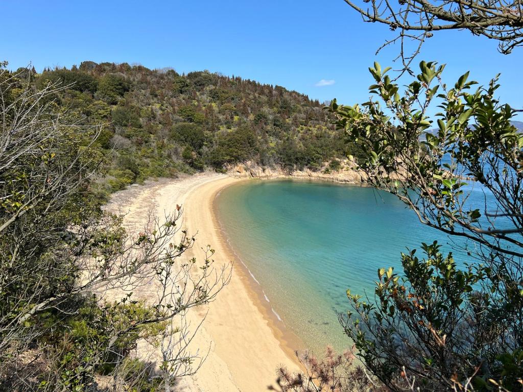 a view of a beach from a hill at 一日限定一組の宿なんでもん in Naoshima