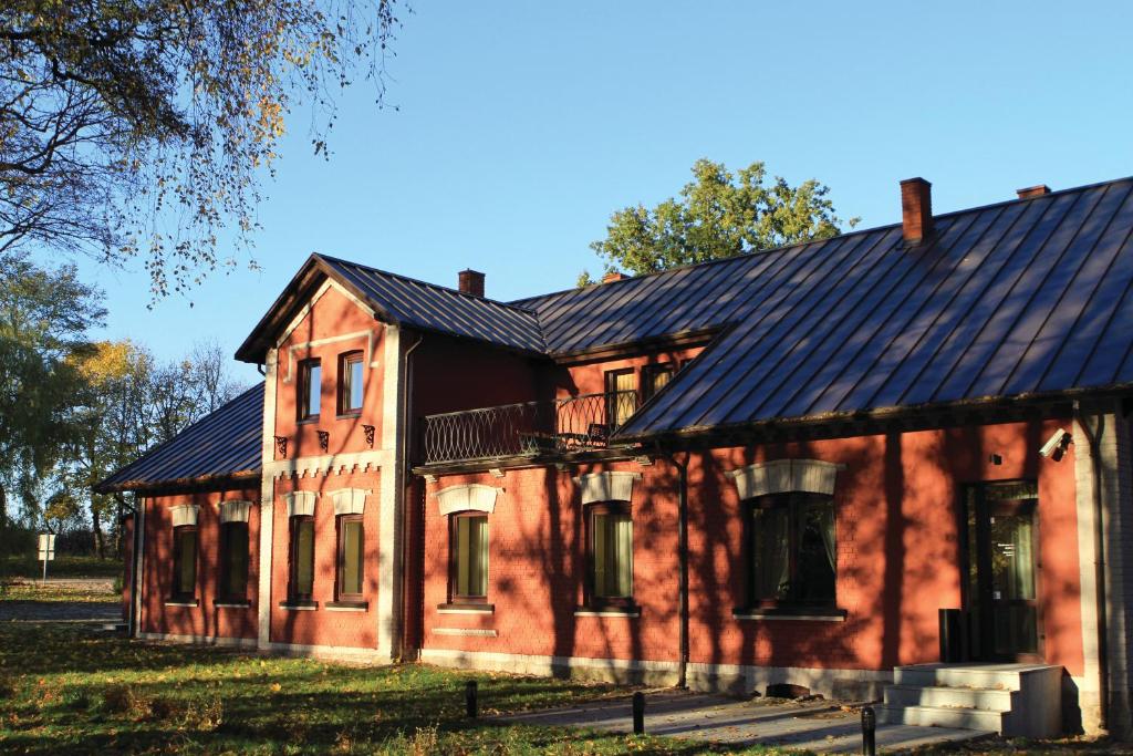 une ancienne maison en briques rouges avec un toit noir dans l'établissement Grafo Zubovo Hotel & SPA, à Bubiai