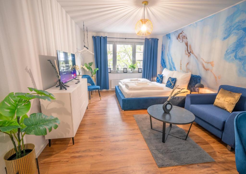 ein Wohnzimmer mit einem blauen Sofa und einem Bett in der Unterkunft Noble Studio - 1 Min to HBF in Mannheim