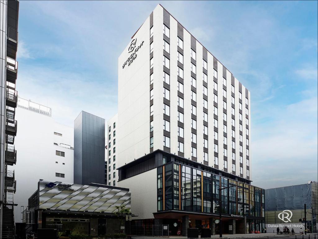 Daiwa Roynet Hotel Sendai Nishiguchi PREMIER في سيندايْ: مبنى أبيض طويل عليه علامة