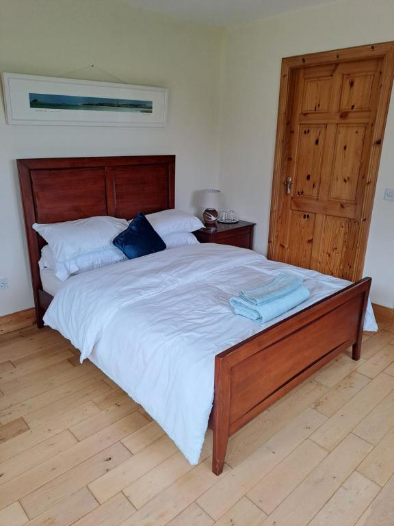 - une chambre avec un grand lit et une tête de lit en bois dans l'établissement Beachmount house, à Cork