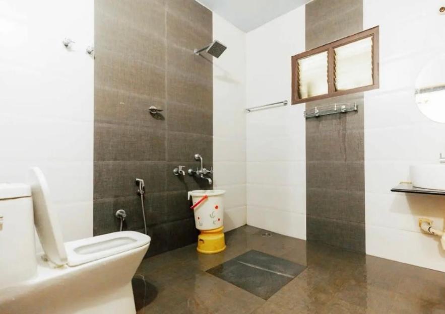 a bathroom with a toilet and a shower and a sink at Saaranga homestay in Avathi